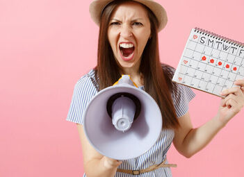 Eine Frau hält einen Kalender und ein Megafon in der Hand. Sie schreit etwas in das Megafon.